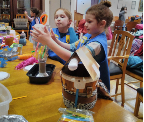 Children in a classroom making bird feeders from recycled materials